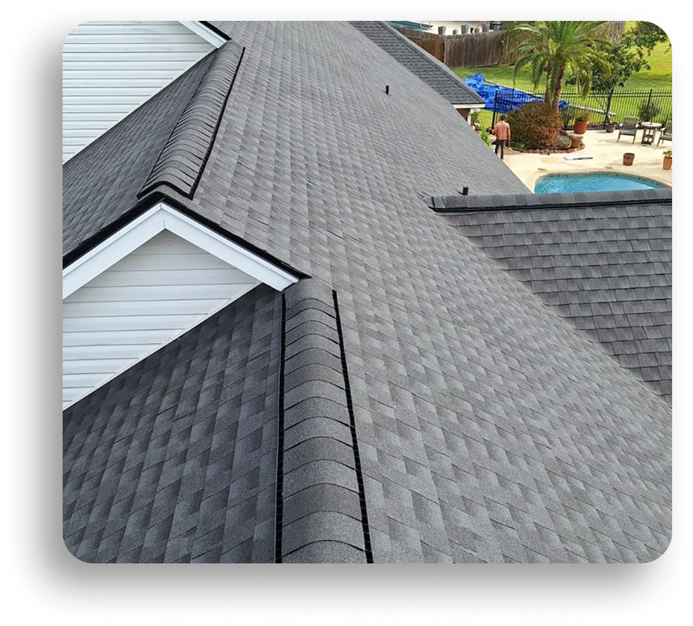 A close-up view of a house roof with uniform, dark gray asphalt shingles, expertly installed by American Patriot Roofing. In the background, a swimming pool and landscaped yard capture the charm of North Texas living.